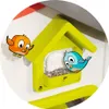Cartoon birds interacting with a toy birdhouse filled with seeds. Produktbild-Vorschau