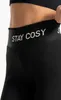 Close-up of the waistband of black leggings with the text 'STAY COSY' printed on it. Produktbild-Vorschau