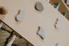 A close-up view of a wooden climbing triangle with pastel-colored geometric shapes attached. Voir les images du produit