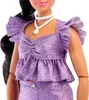 Close-up of a doll wearing a sparkly purple outfit and a white necklace. Produktbild-Vorschau