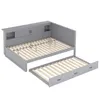 A grey daybed with a trundle bed pulled out, showing its slatted bases and storage compartments. Podgląd zdjęcia produktu