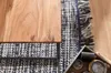 A close-up of a wooden coffee table on a rug, with decorative items in a tray. Produktbild-Vorschau