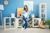 A young woman is dancing and listening to music with headphones in a room. Náhled obrázku produktu