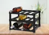 A black wine rack holding six bottles of wine, placed on a wooden table. Produktbild-Vorschau