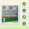A green raised garden bed filled with flowers, set against a stone wall and fence. Produktbild-Vorschau