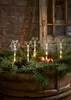 Four snowflake-shaped LED lights are placed among pine branches and apples on a wooden barrel. Podgląd zdjęcia produktu