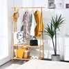 A bamboo clothing rack with clothes and accessories displayed on it, set in a room. Anteprima dell’immagine prodotto
