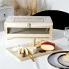 A cheese cellar with a serving tray filled with various cheeses and crackers. Voir les images du produit