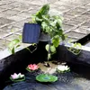 A solar-powered fountain with decorative lotus flowers in a pond, next to a potted plant and a solar panel. Produktbild-Vorschau