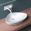 A white ceramic vessel sink with a modern faucet mounted on a teal wall, resting on a wooden countertop. Produktbild-Vorschau