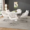 A dining room setting with a marble-topped dining table and six beige upholstered chairs. Náhľad obrázku produktu