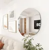 A modern living room with a large, frameless, irregularly shaped mirror reflecting the room. Produktbild-Vorschau