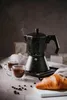 A coffee maker with two cups of coffee and a croissant. Náhľad obrázku produktu