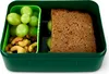 A green lunchbox containing a sandwich, grapes, and nuts. Produktbild-Vorschau