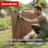 A man is installing a brown privacy screen onto a chain-link fence in a garden setting. Produktbild-Vorschau