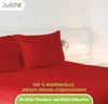 A red bed with pillows and a bedside lamp. Produktbild-Vorschau