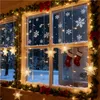A decorated window with Christmas lights and snowflakes, showing a winter scene outside. Voir les images du produit