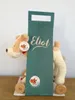 A plush toy dog with wooden wheels and a teal gift bag. Anteprima dell’immagine prodotto