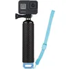 A black action camera is mounted on a black textured grip with a blue wrist strap attached. Produktbild-Vorschau