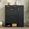A dark gray shoe cabinet with gold handles is shown in a room with light green paneled walls and a potted plant. Podgląd zdjęcia produktu