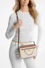 A woman is modeling a Michael Kors handbag. Produktbild-Vorschau