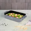 A gray roasting pan filled with shrimp and broccoli sits on a marble countertop, with a wooden wall in the background. Náhled obrázku produktu