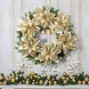 A Christmas wreath and garland decorated with gold poinsettias and ornaments, displayed on a white paneled wall and mantelpiece. Produktbild-Vorschau