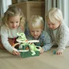 Three young children are playing with a toy dinosaur slide. Náhled obrázku produktu