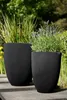 Two black planters with plants in a garden setting. Náhľad obrázku produktu