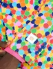A close-up shot of a man's arm wearing a colorful suit jacket with a confetti pattern. Anteprima dell’immagine prodotto