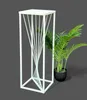 A white metal plant stand with a twisted design is shown next to a potted green plant. Anteprima dell’immagine prodotto