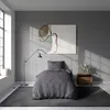 A bedroom scene with a bed, nightstand, lamp, and artwork. Produktbild-Vorschau
