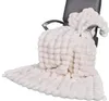 A cream-colored faux fur blanket draped over a black office chair. Produktbild-Vorschau