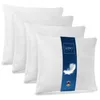 A set of four white pillows, with one pillow in the foreground featuring a blue band with product information.