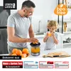 A father and son are in a kitchen, making fresh orange juice with an electric juicer. The son is drinking juice from a glass. Produktbild-Vorschau