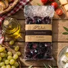 Gaia Kallisti Kalamata-Oliven auf Holzbrett mit Olivenöl Produktbild-Vorschau