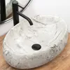 A marble basin with a black faucet on a wooden surface. Anteprima dell’immagine prodotto