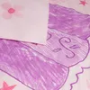 A close-up view of a pink and purple children's duvet cover with a floral pattern and a drawing of a character. Podgląd zdjęcia produktu