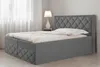 A dark gray upholstered bed with a diamond-stitched headboard and base, shown in a bedroom setting with sheer curtains and a bedside lamp. Produktbild-Vorschau