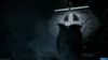 A dark, atmospheric scene with a large alien egg in the foreground, facing a closed metallic door. Produktbild-Vorschau