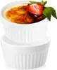 Two white ceramic ramekins, one stacked on top of the other. The top ramekin contains a crème brûlée topped with a strawberry slice and mint leaves. Anteprima dell’immagine prodotto