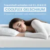 A woman sleeping peacefully on a mattress with a pillow. Produktbild-Vorschau