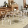 A dining table set with four chairs is arranged in a room with a fireplace. Voir les images du produit