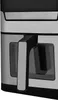 A close-up view of the side of a black and silver air fryer, showing its handle and transparent windows. Anteprima dell’immagine prodotto