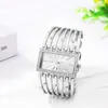 A silver women's watch with a rectangular face and a decorative bracelet is displayed on a white surface. Produktbild-Vorschau