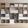 A modular shoe storage unit filled with shoes and folded clothes. Produktbild-Vorschau