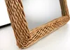 A close-up view of a woven wicker mirror frame. Náhled obrázku produktu