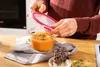 A person is closing the lid on a glass food container filled with orange soup. Náhľad obrázku produktu