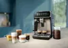 A fully automatic espresso machine is displayed on a countertop with several cups of coffee and a jar of coffee beans. Produktbild-Vorschau