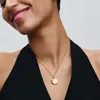 A woman wearing a gold pendant necklace. Anteprima dell’immagine prodotto